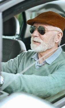 older man at wheel of car