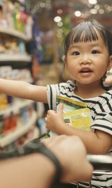 child pointing at supermarket shelf