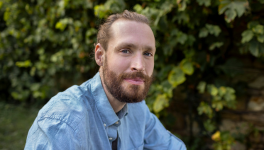 Portrait of a person outside smiling in a denim shirt