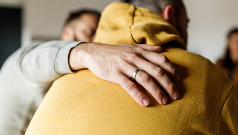Man wrapping arm around friend