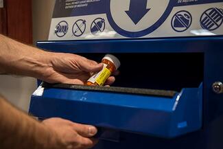 hands placing medication in kiosk